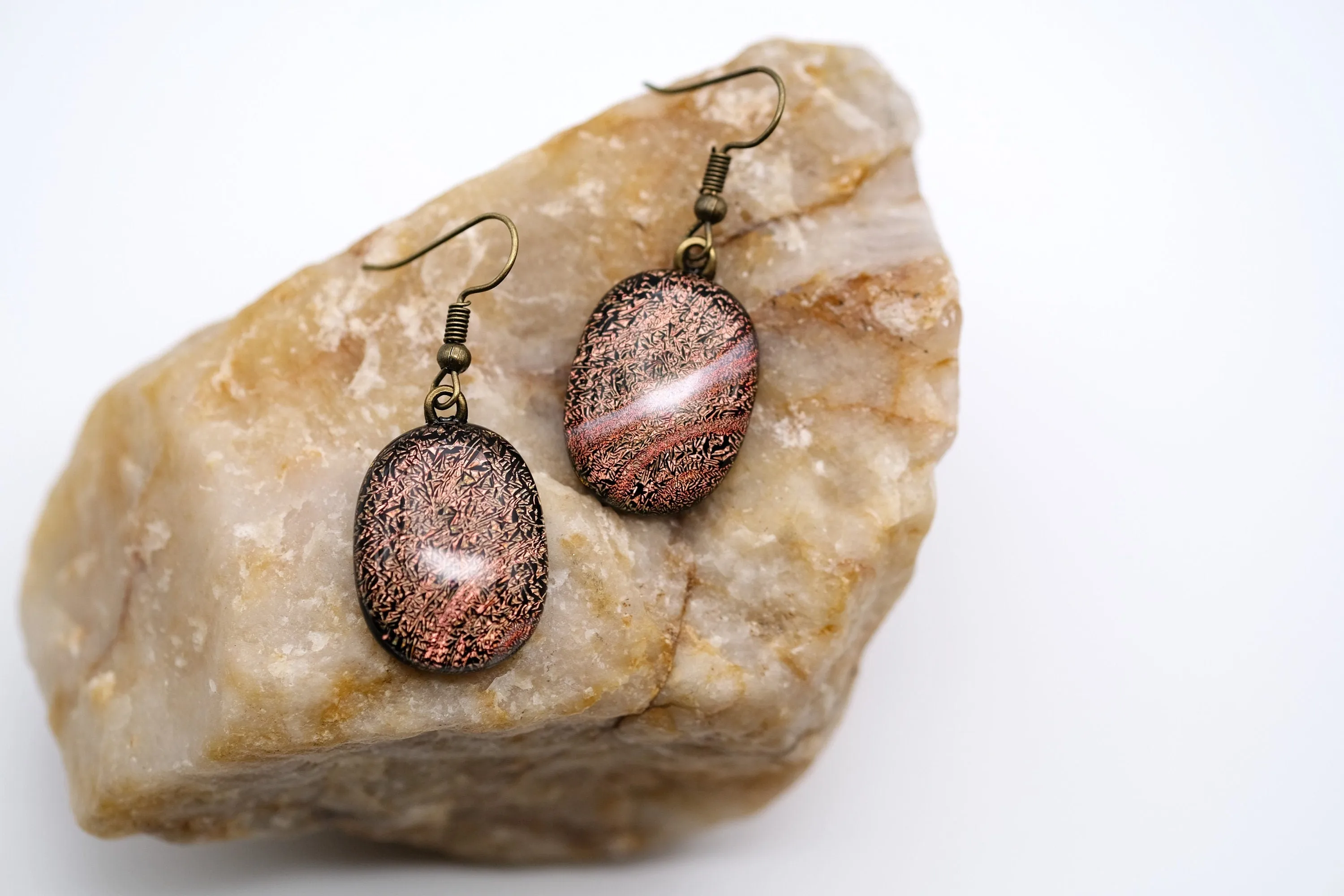 Dichroic orange and black fused glass pierced dangling earrings on antiqued brass tone french wires. Approx 1.5 inches total length